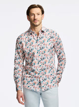 Man wearing a colorful patterned shirt on a light gray background