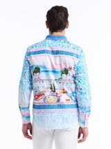 Man wearing a colorful dining and tropical patterned shirt with a white background