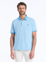 Man wearing a light blue polo shirt with a small DEVIL logo on a white background