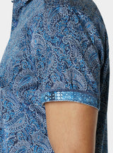 Close-up of a blue paisley patterned shirt on a plain background