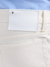Close-up of a white pants label with a blue shirt background