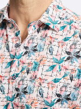 Close-up of a patterned shirt with blue, pink, and black design on a white background