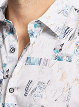 Close-up of a person wearing a white shirt with abstract blue and black patterns.