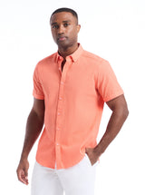 Man wearing a coral short-sleeve shirt on a white background