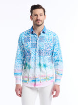 Man wearing a colorful patterned shirt with palm trees and a beach pictured