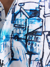 Close-up of a shirt with blue and black abstract street scene design.