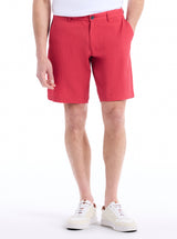 Person wearing red shorts and white sneakers on a white background