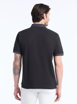 Man wearing a black polo shirt with a white background