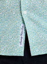 Close-up of a floral-patterned shirt with a label on a black background