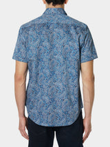 Man wearing a blue paisley patterned shirt on a white background